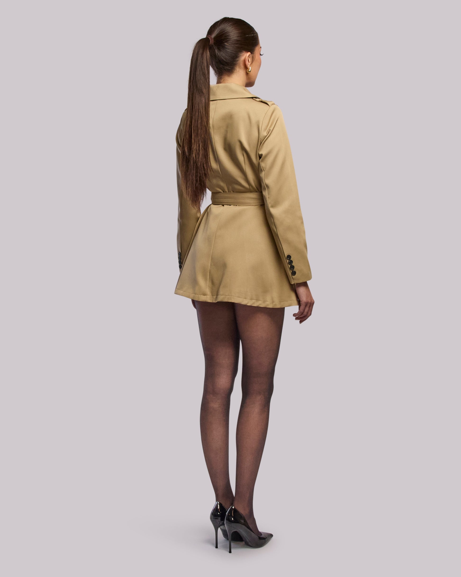 Model wearing Diva short trench coat  standing back angle