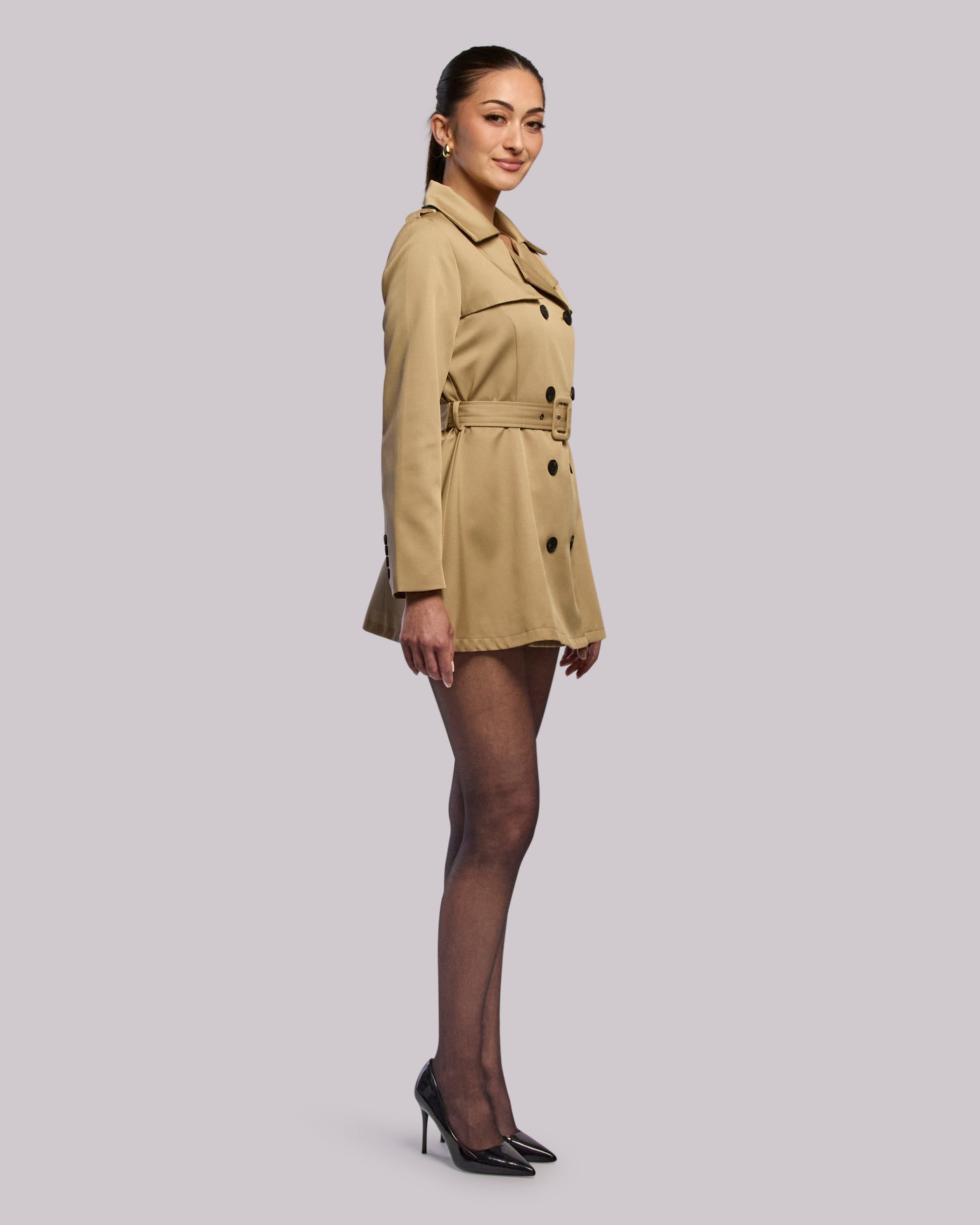 Model wearing Diva short trench coat  standing side angle
